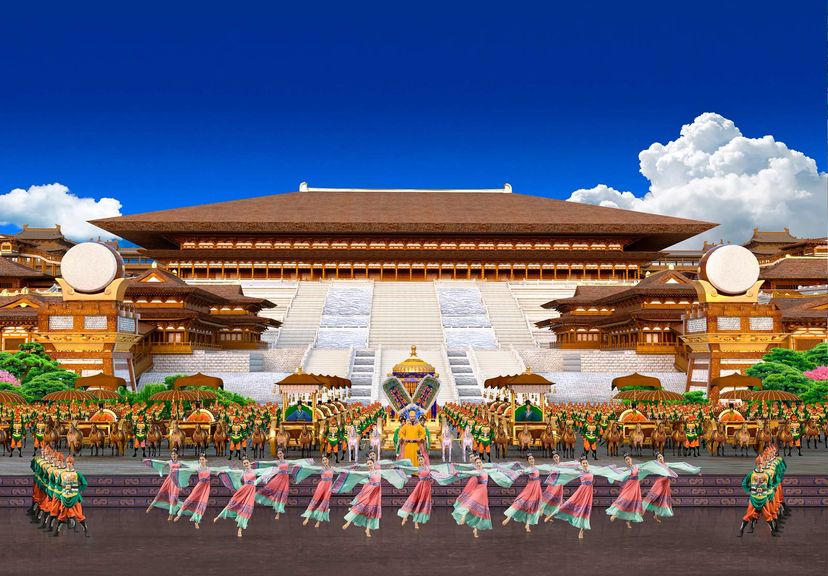 宮殿を映し出した背景スクリーンの前で踊る大群舞